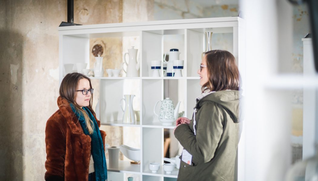 2 Besucherinnen vor einem Regal mit Exponaten aus Porzellan